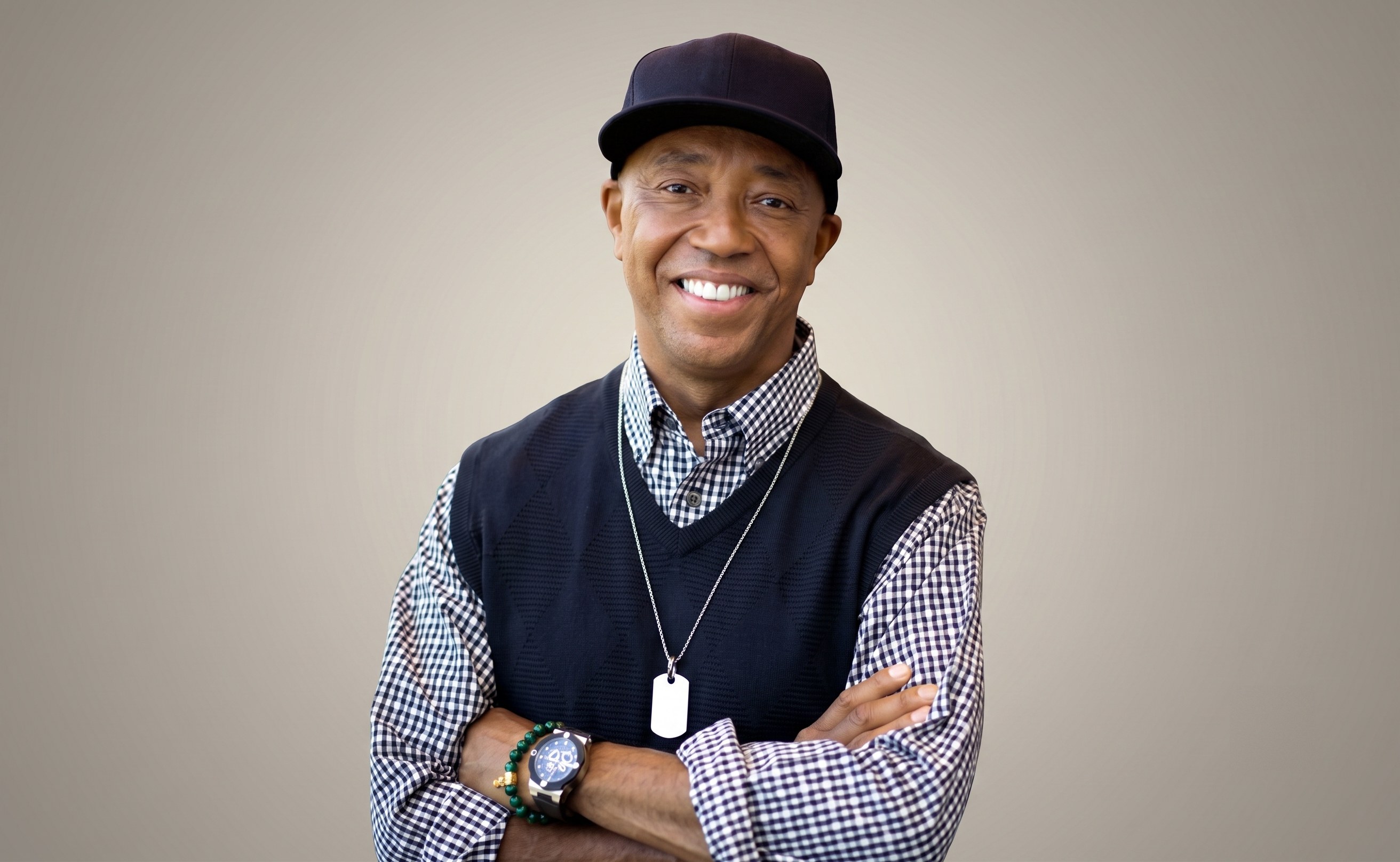 Russell Simmons portrait, smiling with arms crossed